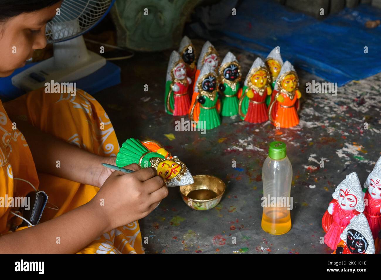 A girl giving final touches to an idol of Subhadra , at a potters hub , ahead of Rath -Yatra celebration in Kolkata , India , on 7 July 2021 . The festival marks the annual celebration to commemorate the arrival of Jagannath to his aunt's home at Gundicha temple near Saradha Bali , Puri . (Photo by Debarchan Chatterjee/NurPhoto) Stock Photo