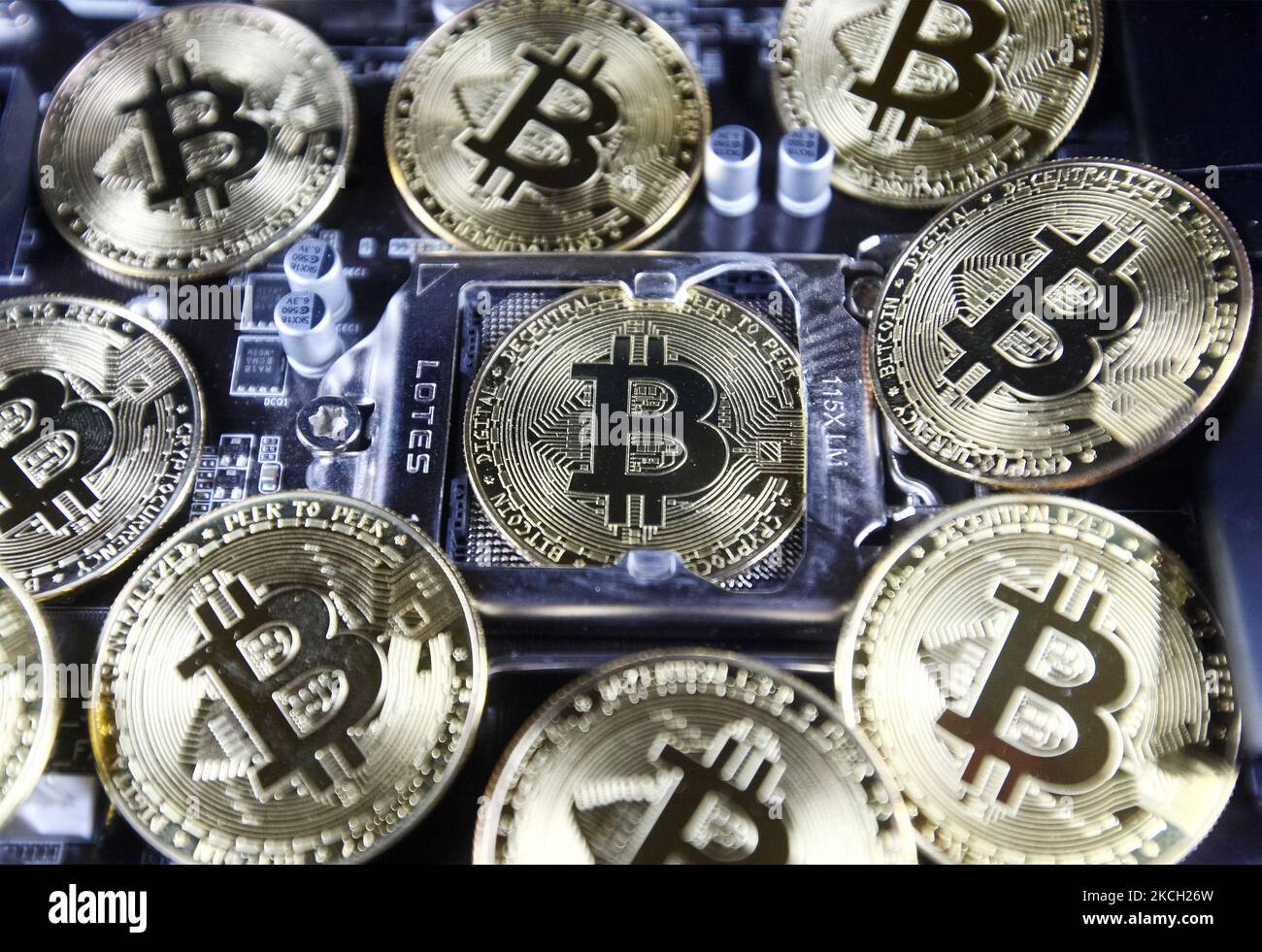 Bitcoin cryptocurrency coins and a PC motherboard are pictured in Kyiv on  08 July, 2021. (Photo by STR/NurPhoto Stock Photo - Alamy
