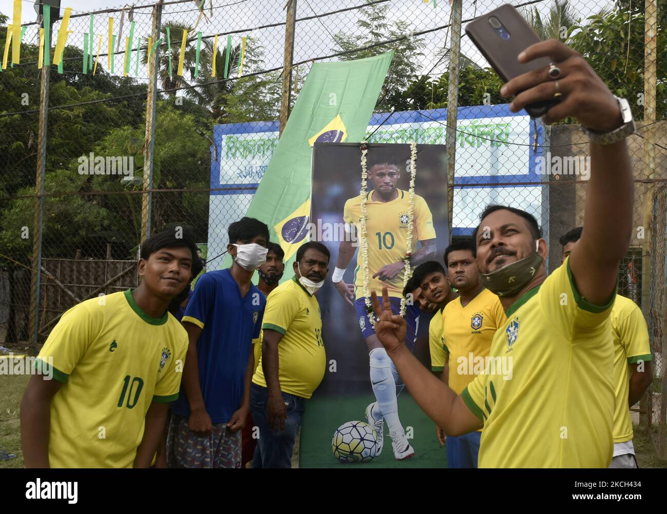 Brazilian takes a selfie picture in front of a photo of Neymar (a professional footballer) ahead of the Copa America final match between Argentina and Brazil, Kolkata, India, 10 July, 2021. (Photo by Indranil Aditya/NurPhoto) Stock Photo