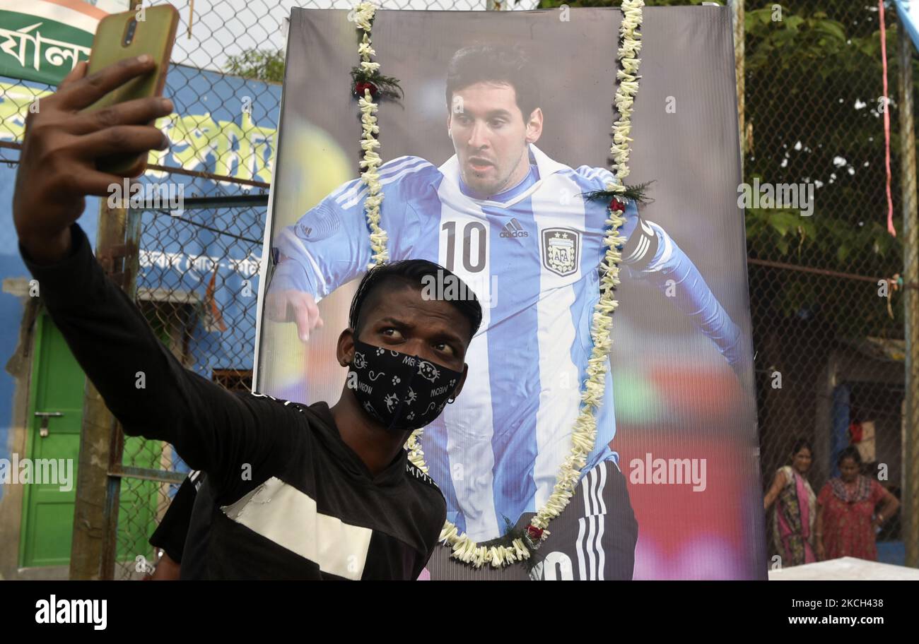An Argentine fan takes a selfie picture in front of a photo of Lionel Messi (a professional footballer) ahead of the Copa America final match between Argentina and Brazil, Kolkata, India, 10 July, 2021. (Photo by Indranil Aditya/NurPhoto) Stock Photo