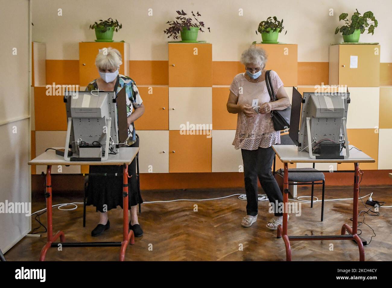 People casting their vote during early parliamentary elections in Sofia, Bulgaria on 11 July, 2021. Voting takes place in 13,012 polling stations across the country. In 9,401 of them, voting is with machines only. Paper ballots will be used in polling stations with less than 300 voters. (Photo by Georgi Paleykov/NurPhoto) Stock Photo