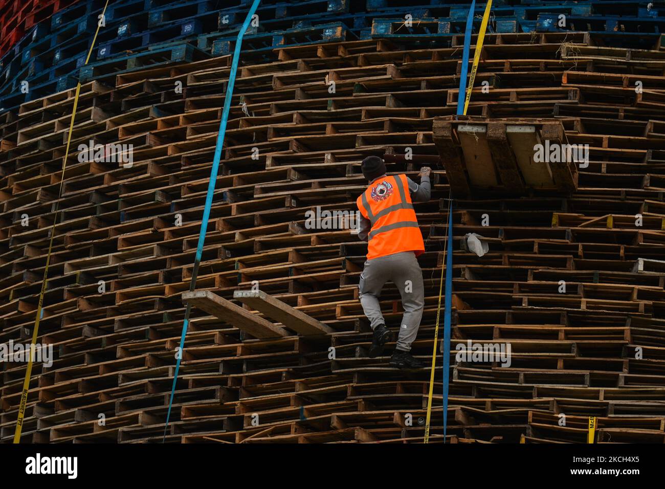 A bonfire builder works on the 11th Night bonfire in Craigy Hill, Larne, ahead of the July 11th celebration organized by members of the Loyalists Orders. The bonfire consists of 17,000 pallets (286 pallets high equivalent of 45 metres) collected by the Loyalists to mark the opening of the annual Orange Parade on July 12. The parade celebrates the victory of the Protestant King William of Orange over the Catholic King James II at the Battle of Boyne in 1690. On Sunday, 11 July 2021, in Larne, County Antrim, Northern Ireland (Photo by Artur Widak/NurPhoto) Stock Photo