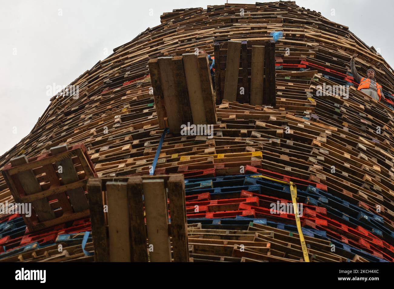 A bonfire builder takes a selfie as he works on the 11th Night bonfire in Craigy Hill, Larne, ahead of the July 11th celebration organized by members of the Loyalists Orders. The bonfire consists of 17,000 pallets (286 pallets high equivalent of 45 metres) collected by the Loyalists to mark the opening of the annual Orange Parade on July 12. The parade celebrates the victory of the Protestant King William of Orange over the Catholic King James II at the Battle of Boyne in 1690. On Sunday, 11 July 2021, in Larne, County Antrim, Northern Ireland (Photo by Artur Widak/NurPhoto) Stock Photo