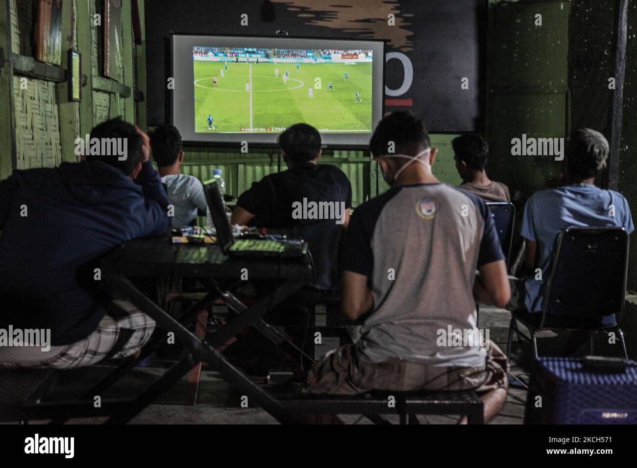 Indonesian men watch the live broadcast of the UEFA EURO 2020 football final match between Italy and England on a small screen in a coffee shop on July 12, 2021 early morning in Medan, Indonesia. The final match ended in a 1-1 draw, in which Italy won on penalties 3 -2. (Photo by Ivan Damanik/NurPhoto) Stock Photo