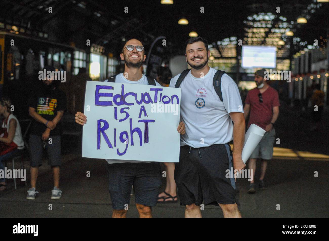 Carlos Aponte and Jason Peters pose for one last photo before they start on the first leg of their sixty-two-mile march from Philly to Atlantic City, Carlos holds a sign advocating the right students have to a good education, in Philadelphia, PA on July 16, 2021. (Photo by Cory Clark/NurPhoto) Stock Photo