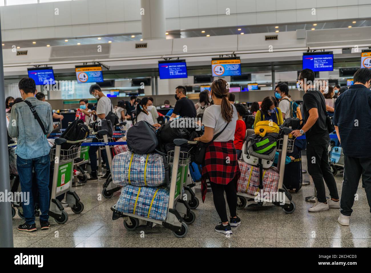 The check-in queue for British Airways in Hong Kong, China, 17 July 2021. Those chequered bags are known by Hongkongers as being a tell-tale sign of migration. (Photo by Marc Fernandes/NurPhoto) Stock Photo