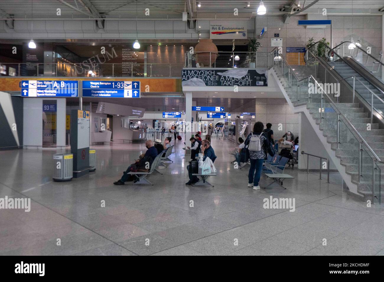 People in the departure hall with the check in desks of Athens airport