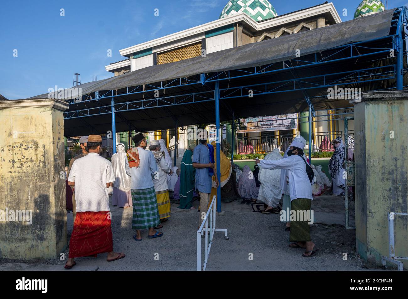 Muslims walk into the mosque to perform Eid al-Adha prayers at the Al ...
