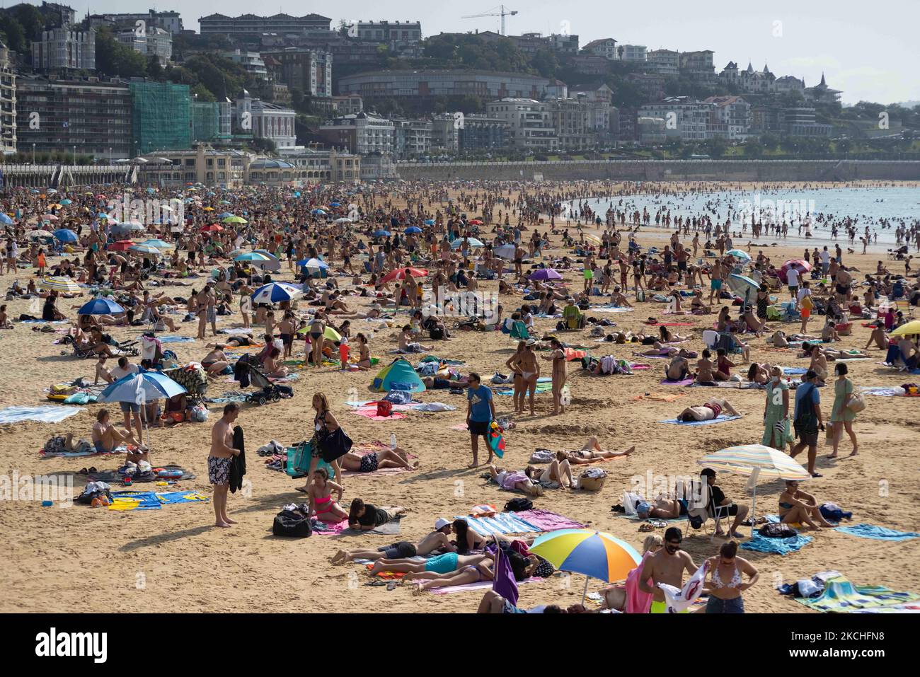 View of La Concha beach in San Sebastian crowded of people, on July 20, 2021. Beachgoers have gathered at the beaches on San Sebastian, Spain at temperatures of almost 30 degrees. Many tourists enjoy sun, sand, waves and sea at the beaches of Spain. (Photo by Manuel Balles/NurPhoto) Stock Photo