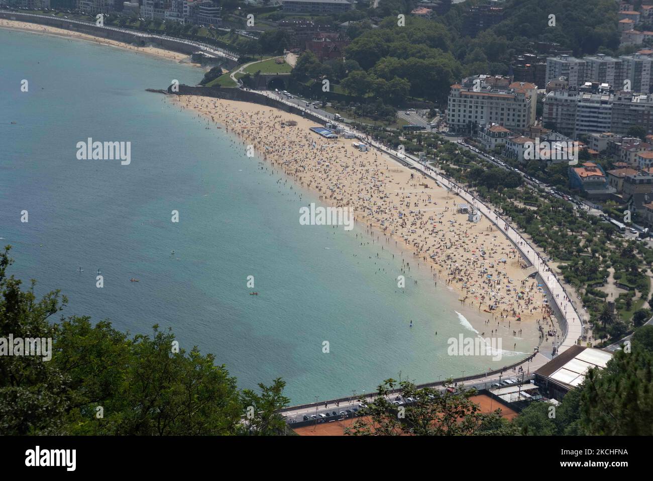 View of Ondarreta beach in San Sebastian crowded of people, on July 20, 2021. Beachgoers have gathered at the beaches on San Sebastian, Spain at temperatures of almost 30 degrees. Many tourists enjoy sun, sand, waves and sea at the beaches of Spain. (Photo by Manuel Balles/NurPhoto) Stock Photo