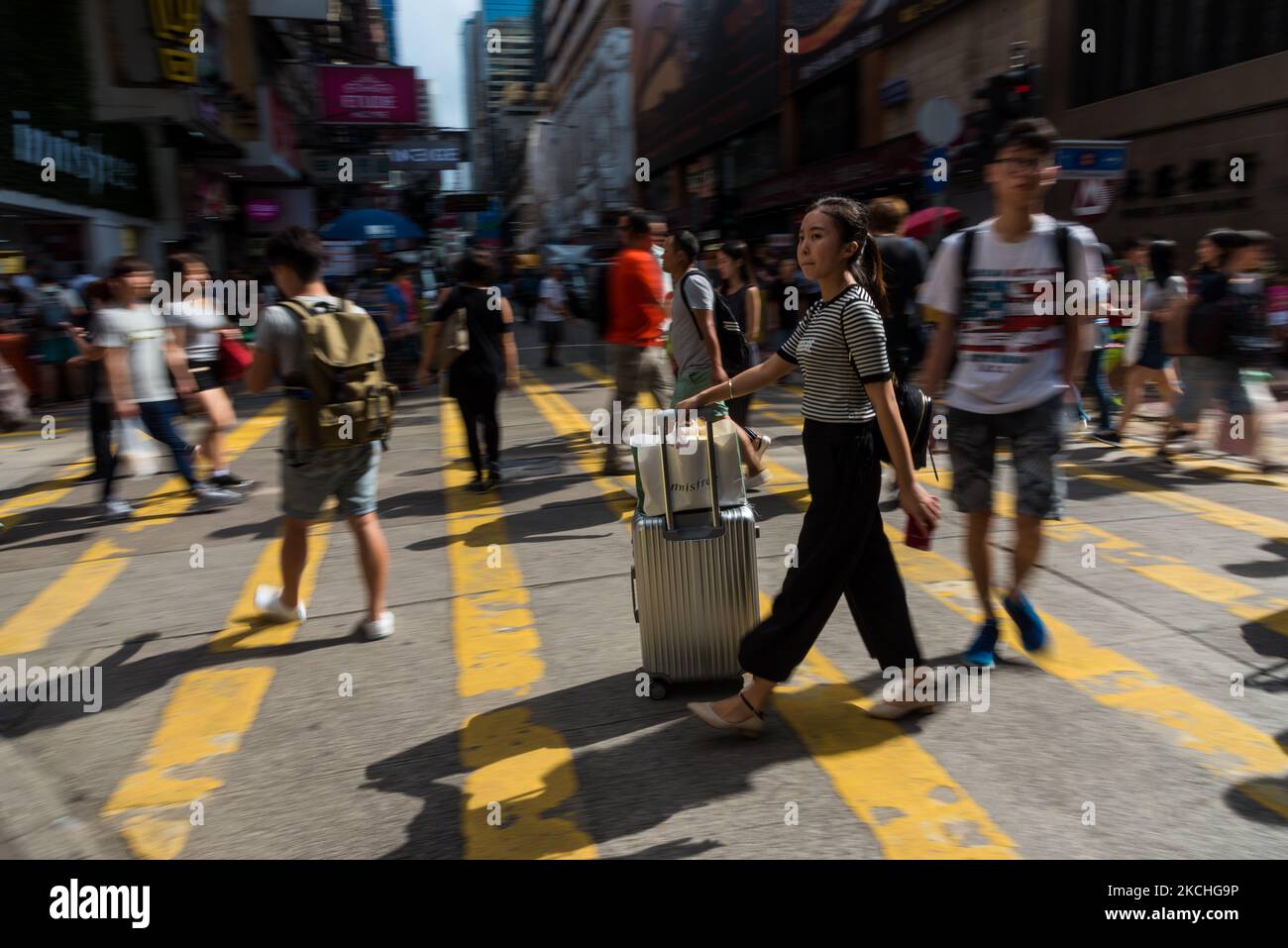 A mainland tourist pushes her suitcase on Sai Yeung Choi South street, In Mongkok, in Hong Kong, China, 23 Sep 2017. Mainland tourists often used those small suitcases to store cosmetics or milk formula to bring back to mainland. (Photo by Marc Fernandes/NurPhoto) Stock Photo