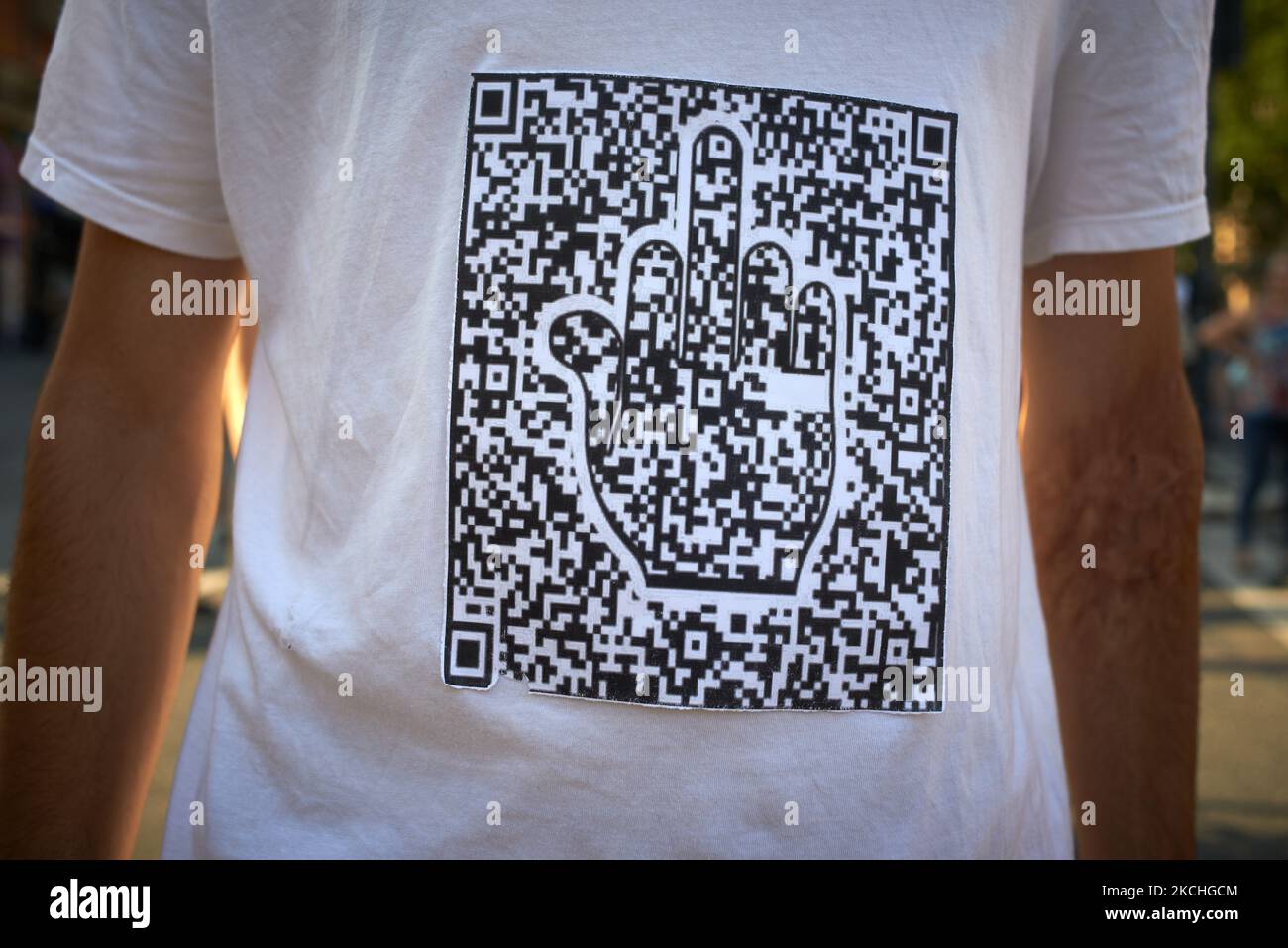 A protester wears a hirt depicting a QR code showing a miffle finger. Between 1500 and 3000 protesters took to the streets in Toulouse against the near mandatory vaccination and against the health pass after the Macron's speech on July 12th. Macron announced the health pass will be mandatory for going in public places such as cafes, theates, concerts hall, cinemas, shops, public transportation (train, bus, tramway), etc. The delay between the first jab and the health pass obtention will be five weeks. But the prohibition for public spaces for non-vaccinated people will go on August 1st. Some s Stock Photo
