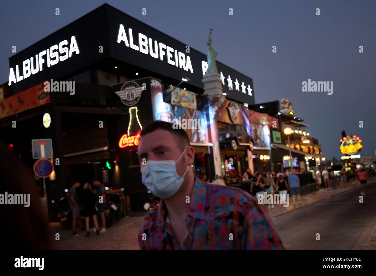 A man walks by a bar in Albufeira, Portugal on July 29, 2021. Portuguese Prime Minister Antonio Costa announced on Thursday a three-stage plan to lift COVID-19 restrictions, including scrapping a night-time curfew, as the country's vaccination rollout speeds up, helping to bring a recent surge in infections under control. From Sunday, localized curfews will end and restrictions on the opening times of restaurants, stores and cultural venues will be lifted, allowing them to stay open till 2 a.m. (Photo by Pedro FiÃºza/NurPhoto) Stock Photo