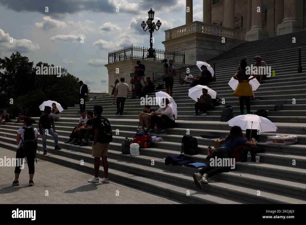 People shield themselves from the mid-day heat with white umbrellas as they continue to protest the end of the pandemic-related eviction moratorium on the Capitol steps in Washington, D.C. on August 3, 2021 (Photo by Bryan Olin Dozier/NurPhoto) Stock Photo