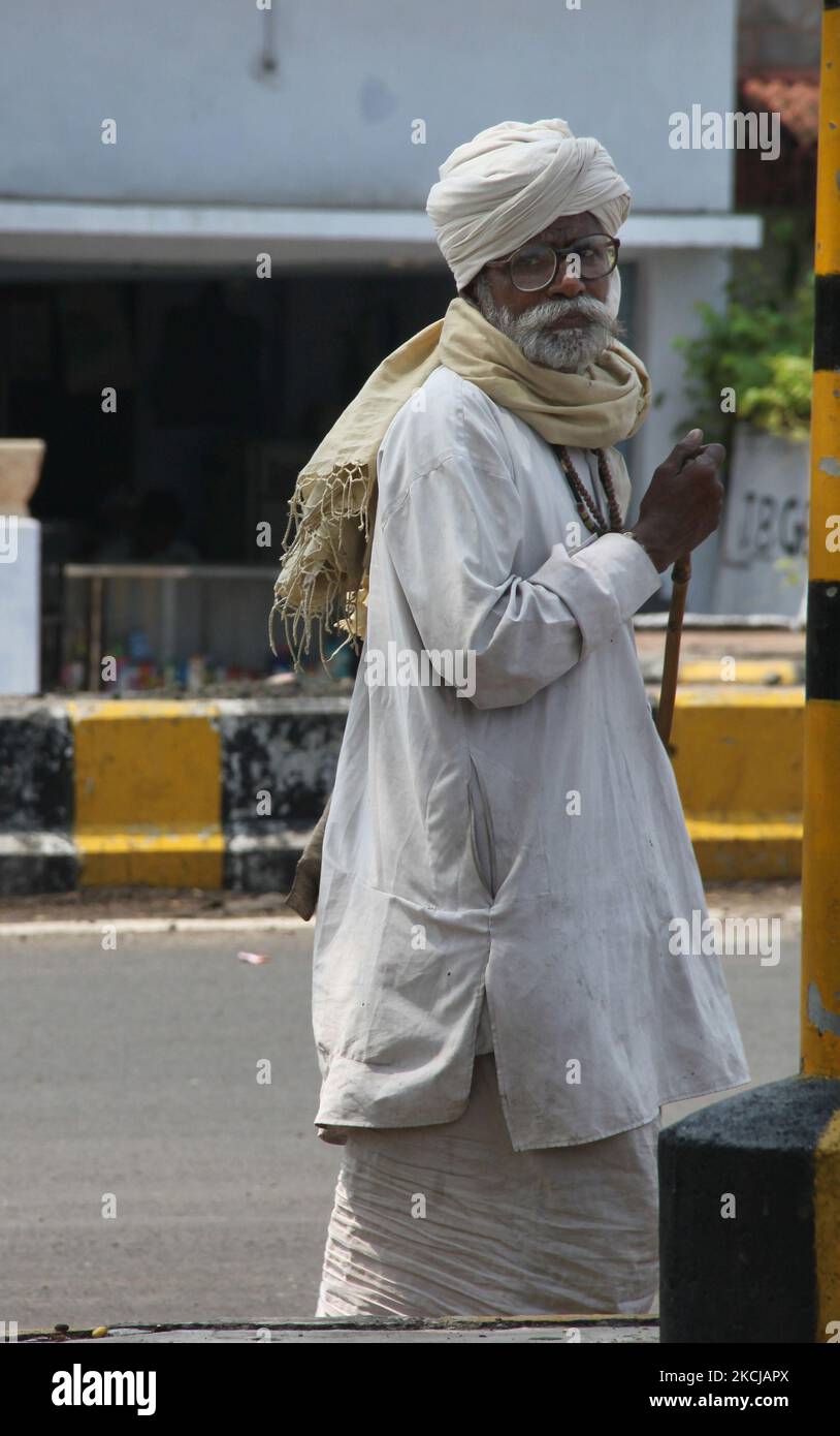 Eelderly beggar walks along the roadside looking for generous motorists to give him a few rupees as alms in the city of Nagpur, Maharashtra, India, on July 19, 2010. (Photo by Creative Touch Imaging Ltd./NurPhoto) Stock Photo
