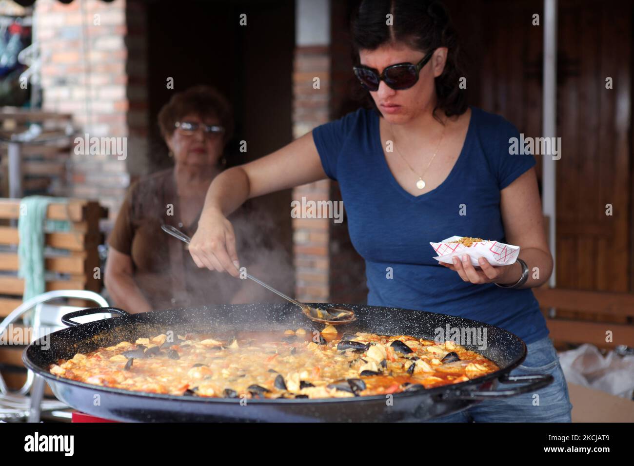 https://c8.alamy.com/comp/2KCJAT9/spanish-woman-serves-paella-from-a-large-pot-outside-a-spanish-restaurant-in-toronto-ontario-canada-on-august-07-2010-photo-by-creative-touch-imaging-ltdnurphoto-2KCJAT9.jpg