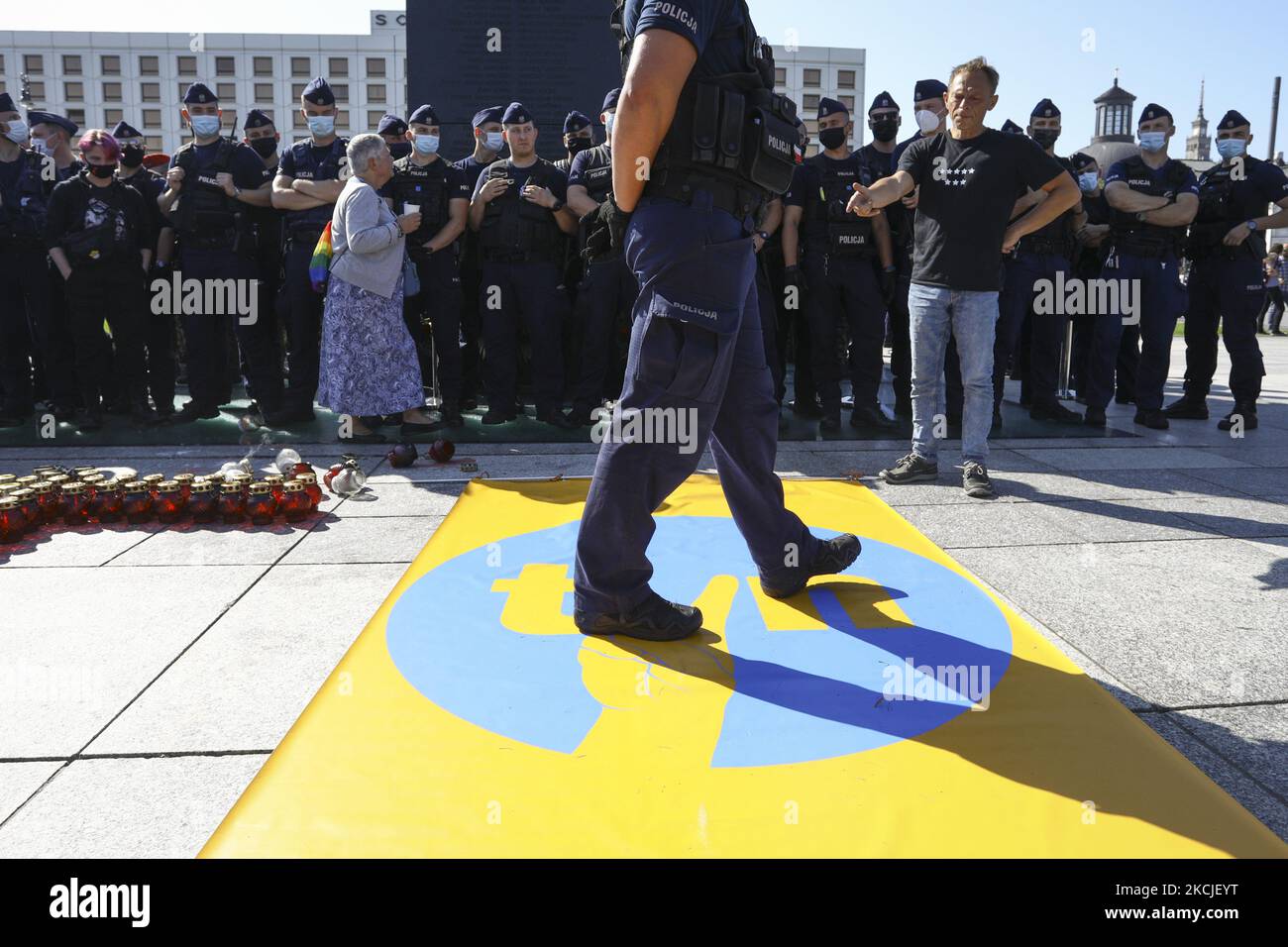 A policeman steps on a banner with the logo of broadcaster TVN modified to resemble a well known symbol of the anti-communist movement in Warsaw, Poland on August 10, 2021. American owned broadcaster TVN's license in Poland will expire at the end of September and the government has indicated it will not renew the license citing converns over it's forerign ownership. Critics argue the non-renewel is a move by the government to shut down critical media outlets. A new bill proposed by lawmakers prohibiting ownership of radio and television outlets by proprietors outside of the European Economic A Stock Photo