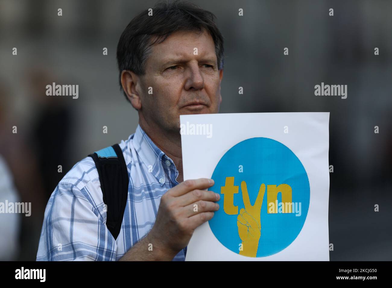 A demonstrator holds up a sign with the TVN logo modified with the communist era V sign indicating solidarity and freedom in Warsaw, Poland on August 10, 2021. Over a thousand people gathered in front of the Sejm, the Polish parliament to protest a law proposal that would ban foreign ownership of media entities. In this case people came out to support the American owned TVN broadcaster whose license will expire in September. The government has indicated it will not renew the license under the current ownership structure, a move critics say could mean the end of independen media in Poland. (Pho Stock Photo