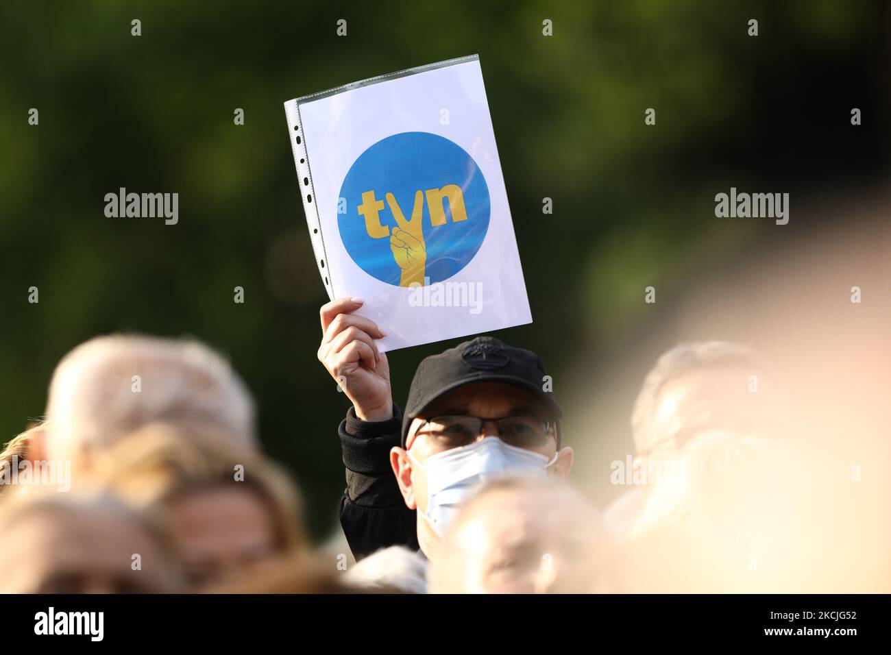 A demonstrator holds up a sign with the TVN logo modified with the communist era V sign indicating solidarity and freedom in Warsaw, Poland on August 10, 2021. Over a thousand people gathered in front of the Sejm, the Polish parliament to protest a law proposal that would ban foreign ownership of media entities. In this case people came out to support the American owned TVN broadcaster whose license will expire in September. The government has indicated it will not renew the license under the current ownership structure, a move critics say could mean the end of independen media in Poland. (Pho Stock Photo