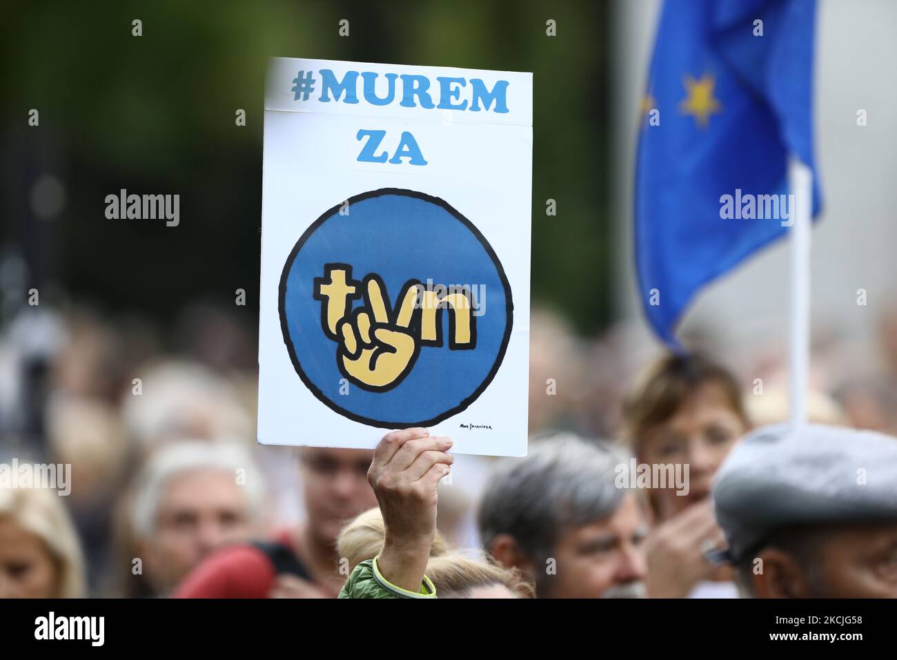 A demonstrator holds up a sign with the TVN logo modified with the communist era V sign indicating solidarity and freedom in Warsaw, Poland on August 10, 2021. Over a thousand people gathered in front of the Sejm, the Polish parliament to protest a law proposal that would ban foreign ownership of media entities. In this case people came out to support the American owned TVN broadcaster whose license will expire in September. The government has indicated it will not renew the license under the current ownership structure, a move critics say could mean the end of independen media in Poland. (Pho Stock Photo