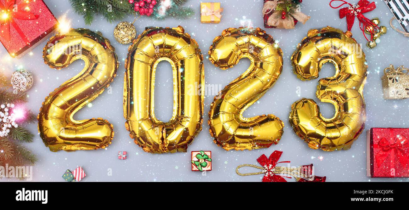 Happy New year 2023 celebration. Foil balloons numeral 2023 and with Glitter Stars .Flat lay. Merry Christmas and Happy Holidays greeting card, frame, Stock Photo