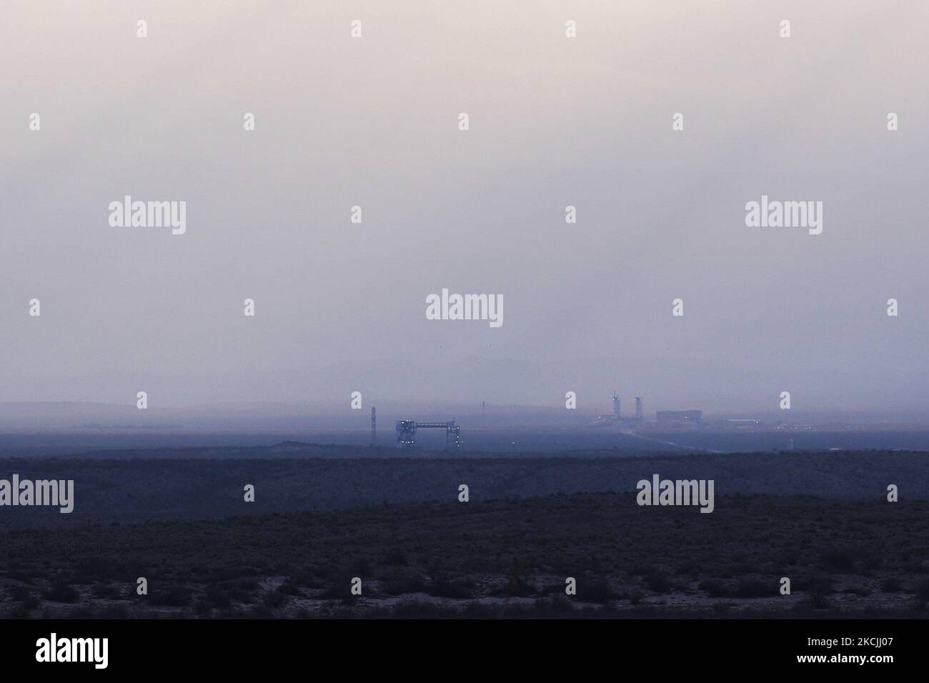 The rocket is seen attached to the fueling tower through the morning