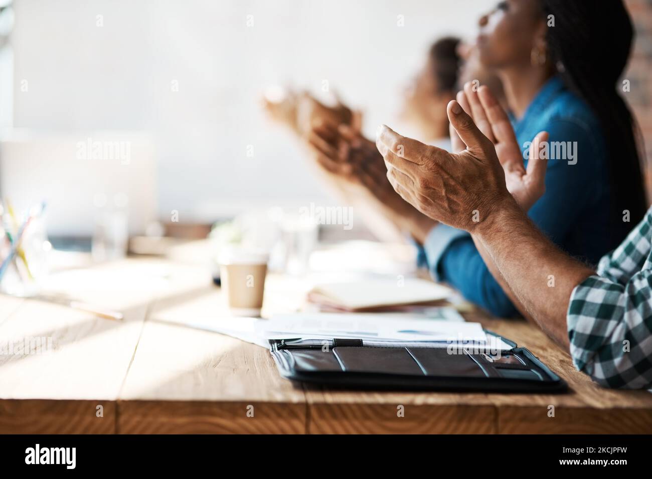 We couldnt agree more a group of businesspeople clapping hands during We couldnt agree more a group of businesspeople clapping hands during