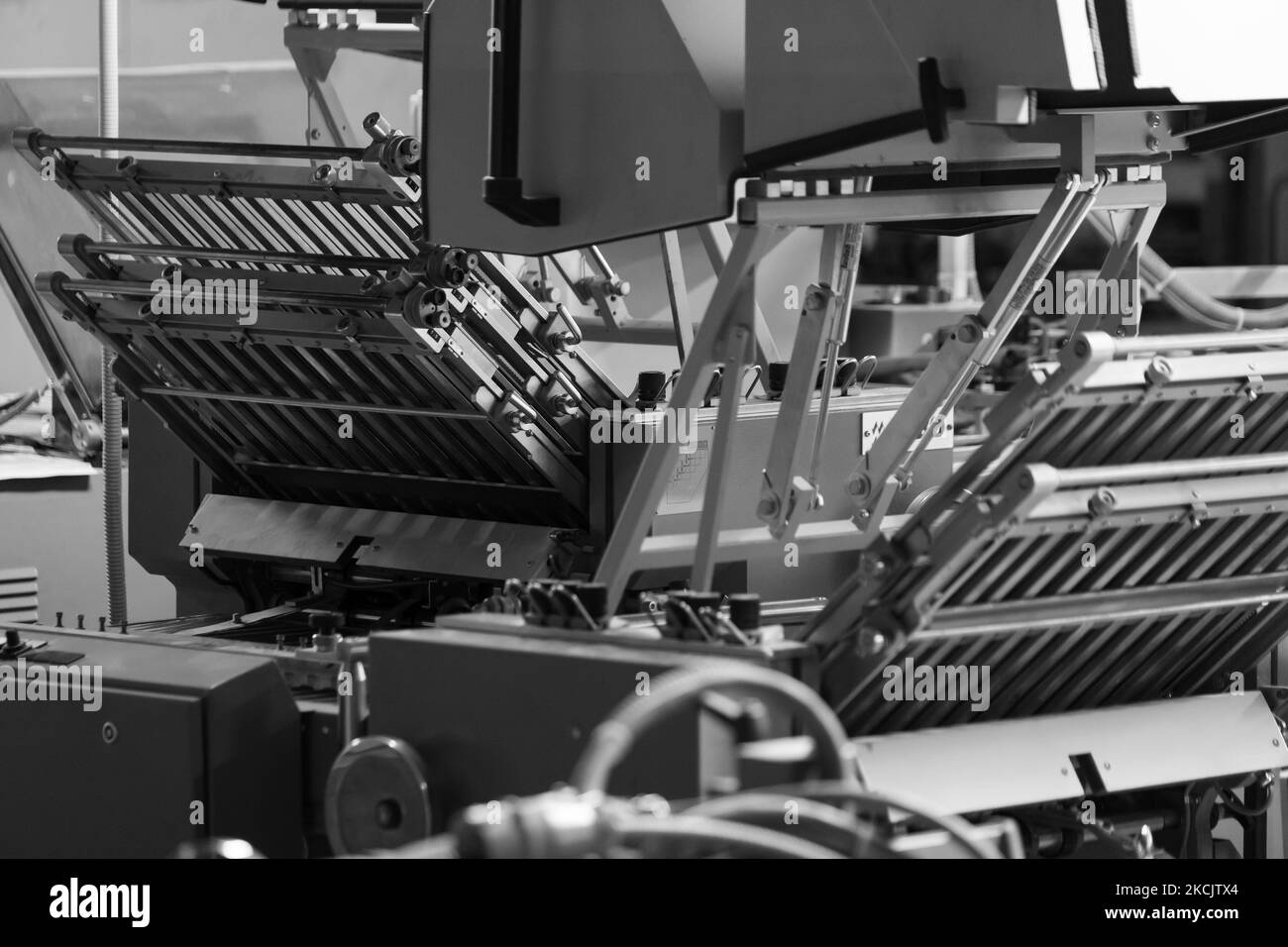 Modern folding machine for newspaper production installed in of print shop black and