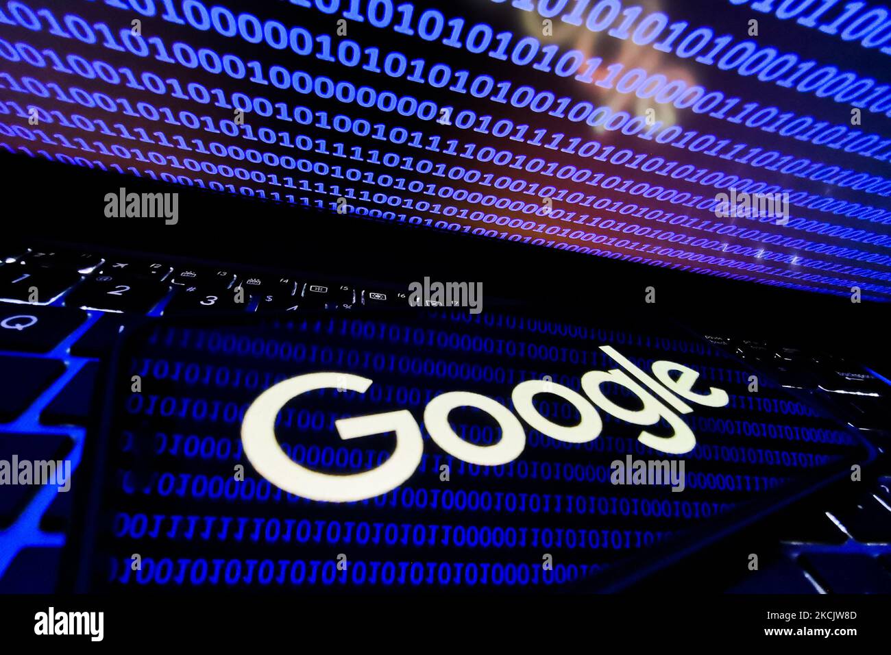 Google logo displayed on a phone screen is seen with binary code ...