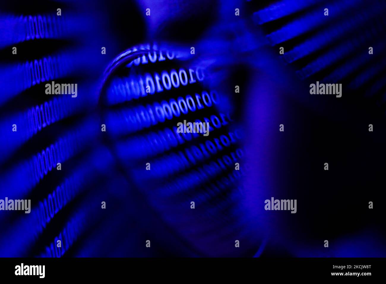 Binary code displayed on a laptop screen is reflected in the sunglasses ...