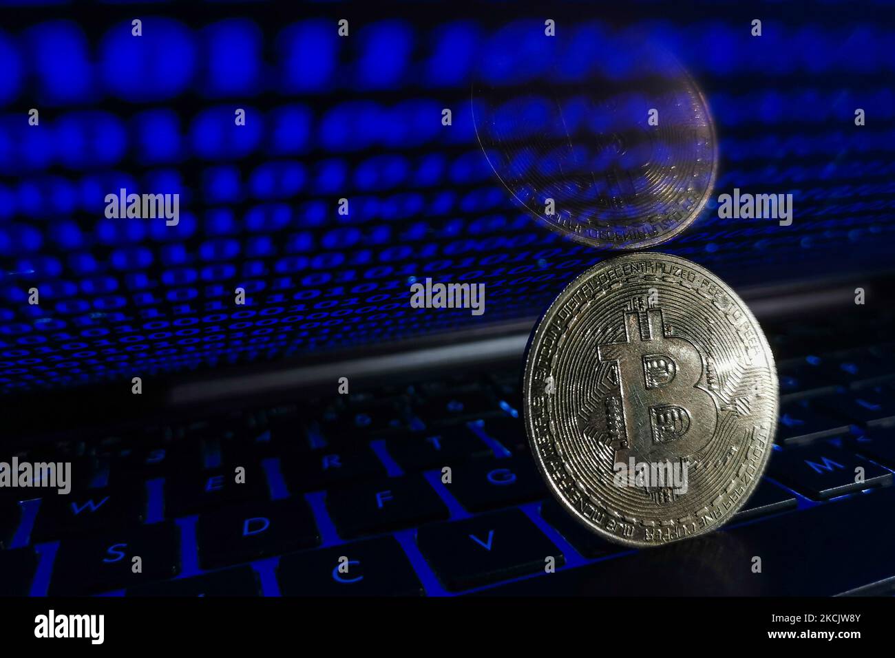 Representation of Bitcoin is seen with binary code displayed on a laptop screen in this illustration photo taken in Krakow, Poland on August 17, 2021. (Photo by Jakub Porzycki/NurPhoto) Stock Photo