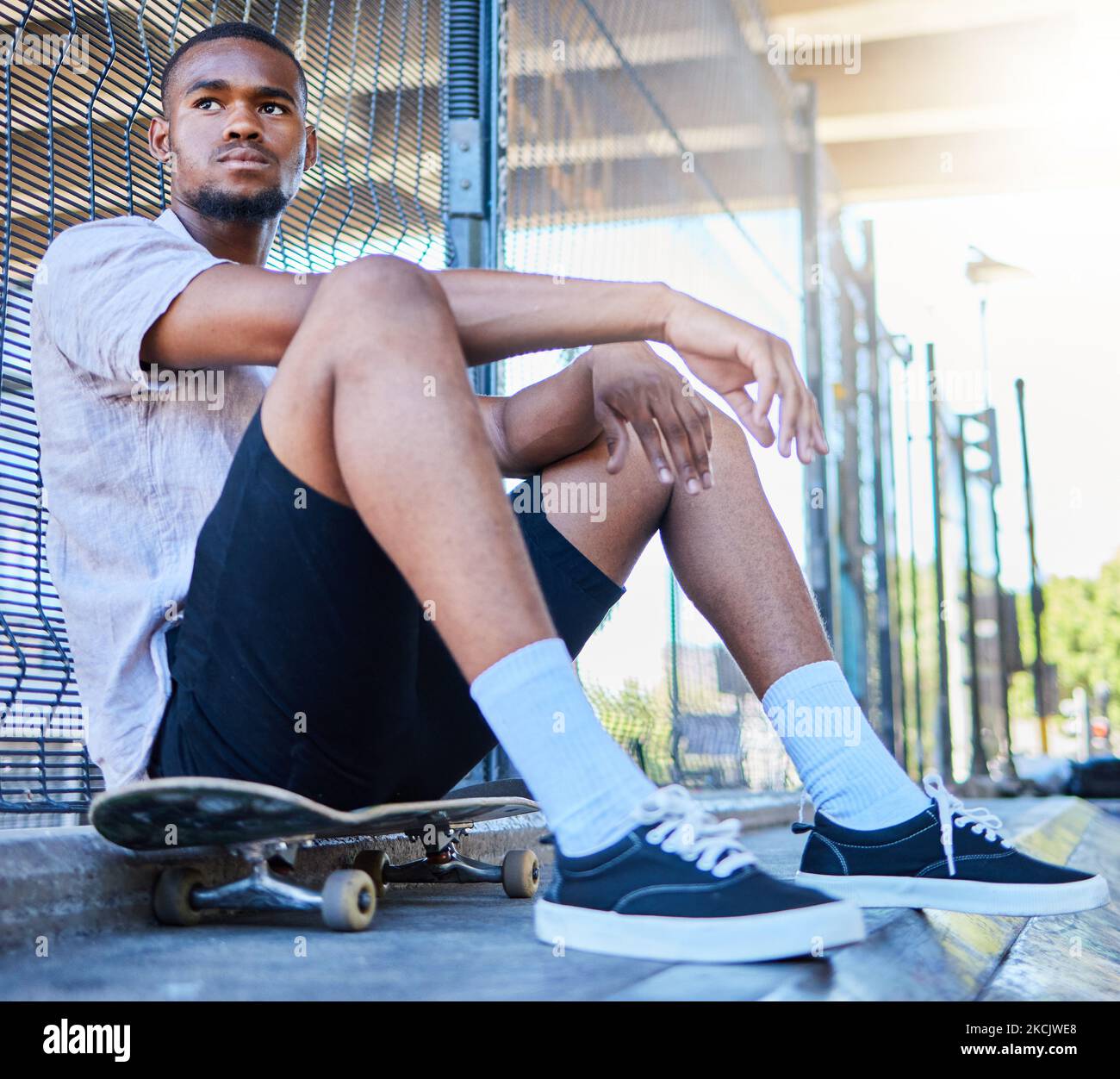 Cool black man, skateboard and freedom at urban skate park, city and relaxing summer for training, outdoor action and sports hobby in USA. Young Stock Photo