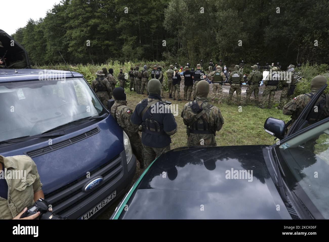 Polish border guards are seen near the border with Belarus on 20 August, 2021 in Usnarz Gorny, Poland. Around 32 Afghan citizens are being held in place on the border by Polish border guards and Belarusian forces. The refugees are now pawns in a game between Lukashenko's regime who is expelling them forcefully over the border in retlation for EU sanctions and the Polish government which says it will protect Poland from illegal migrants.In the last weeks Belarusian authorities have been pushing an increasing number of refugees, mainly from Iraq over the borders of Poland, Lithuania and Latvia.  Stock Photo