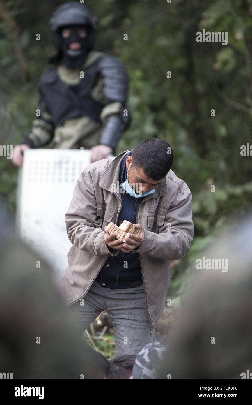 A refugee holds a food in his hands in makeshift camp after illegal border crossing in Usnarz Gorny on August 19, 2021. (Photo by Maciej Luczniewski/NurPhoto) Stock Photo