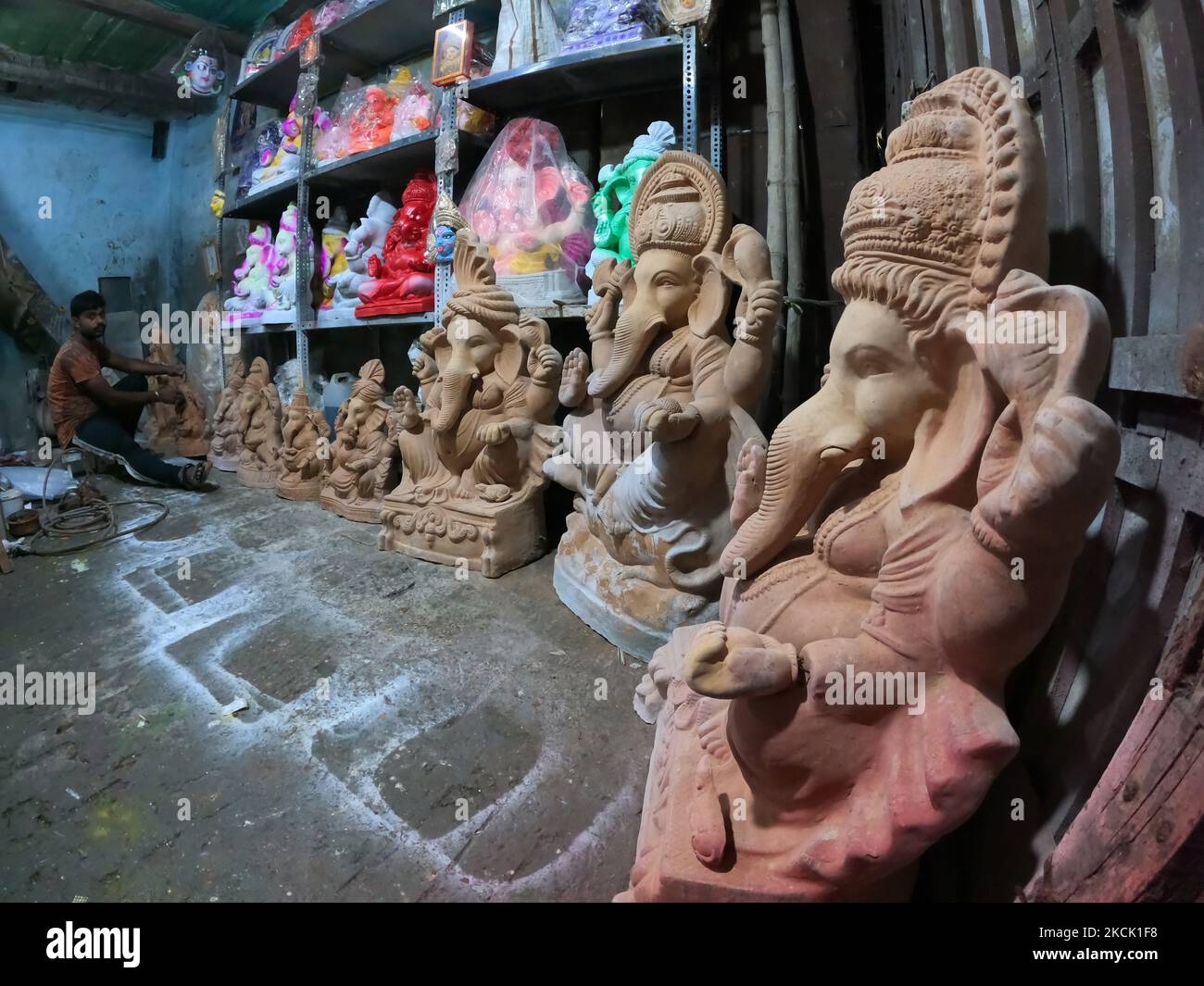 An artisan works on ecofriendly figures of the Hindu deity Ganesh