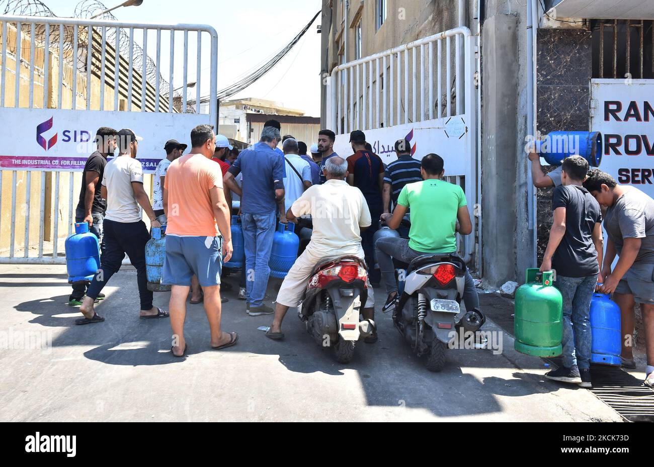 Residents queue outside a gas distribution station to fill gas