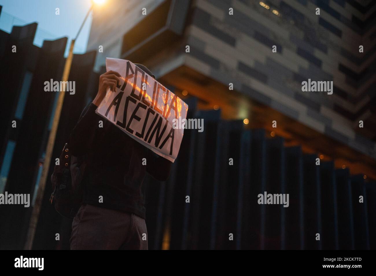 A demonstrator holds a sign that reads 'Killer Police' during a student rally of the Universidad Distrital, after Esteban Mosquera, a social leader and community member was killed two years after loosing his eye on a police brutality case, in Bogota, Colombia on August 26, 2021. (Photo by Sebastian Barros/NurPhoto) Stock Photo