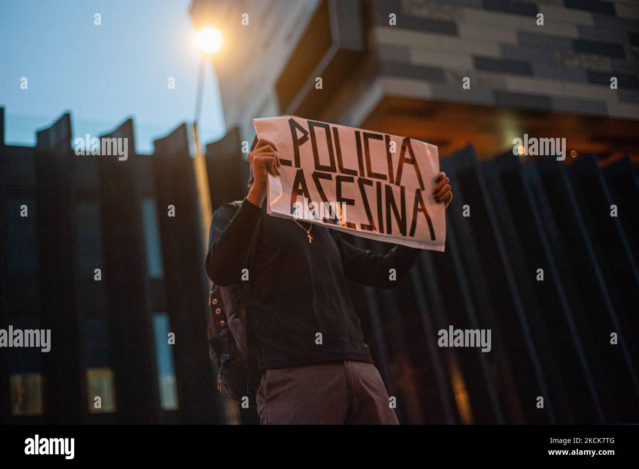 A demonstrator holds a sign that reads 'Killer Police' during a student rally of the Universidad Distrital, after Esteban Mosquera, a social leader and community member was killed two years after loosing his eye on a police brutality case, in Bogota, Colombia on August 26, 2021. (Photo by Sebastian Barros/NurPhoto) Stock Photo