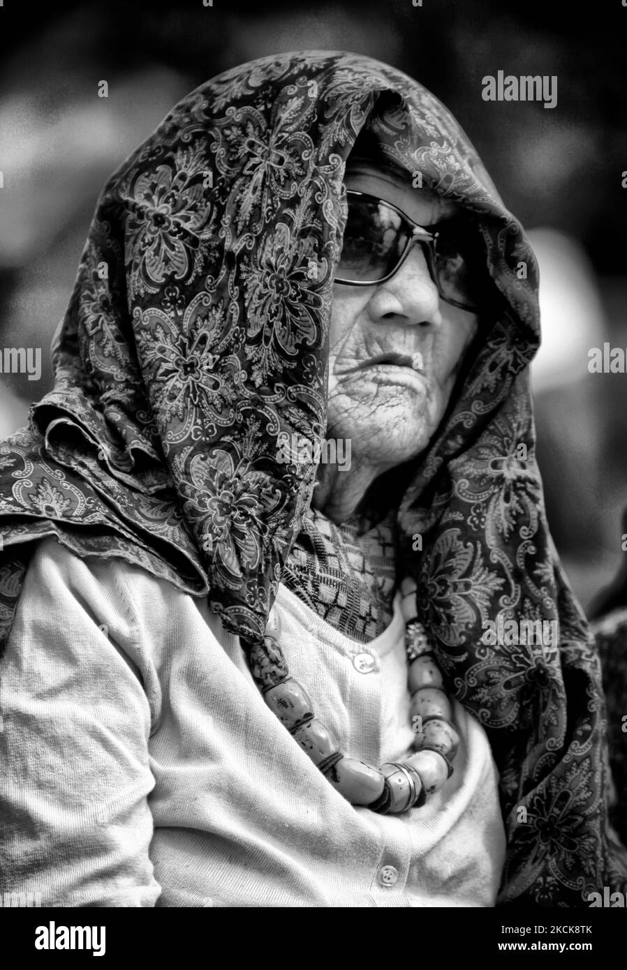 94 year-old Nepali woman covers her head to protect herself from the sun's harmful rays as she watches a cultural dance during the Nepali Himalayan Mela in Toronto, Ontario, Canada, on August 24, 2009. (Photo by Creative Touch Imaging Ltd./NurPhoto) Stock Photo