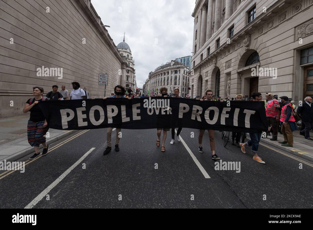 LONDON, UNITED KINGDOM - AUGUST 27, 2021: Environmental activists from Extinction Rebellion march through the City of London in a protest against the companies and institutions that are financing, insuring and enabling major fossil fuel projects and extraction of resources in the developing countries of the Global South, demanding change to the colonial system that drives the crises of climate and racism on 27 August 2021 in London, England. Extinction Rebellion activists target the City of London during the two week 'Impossible Rebellion' action to highlight the role of the UK's financial sec Stock Photo