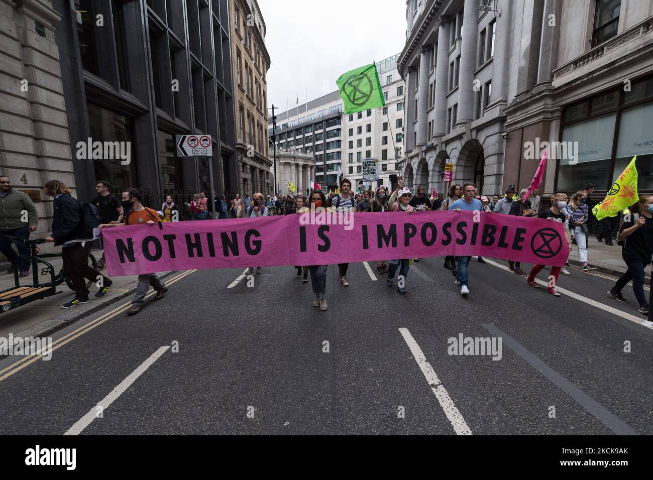 LONDON, UNITED KINGDOM - AUGUST 27, 2021: Environmental activists from Extinction Rebellion march through the City of Londo in a protest against the companies and institutions that are financing, insuring and enabling major fossil fuel projects and extraction of resources in the developing countries of the Global South, demanding change to the colonial system that drives the crises of climate and racism on 27 August 2021 in London, England. Extinction Rebellion activists target the City of London during the two week 'Impossible Rebellion' action to highlight the role of the UK's financial sect Stock Photo
