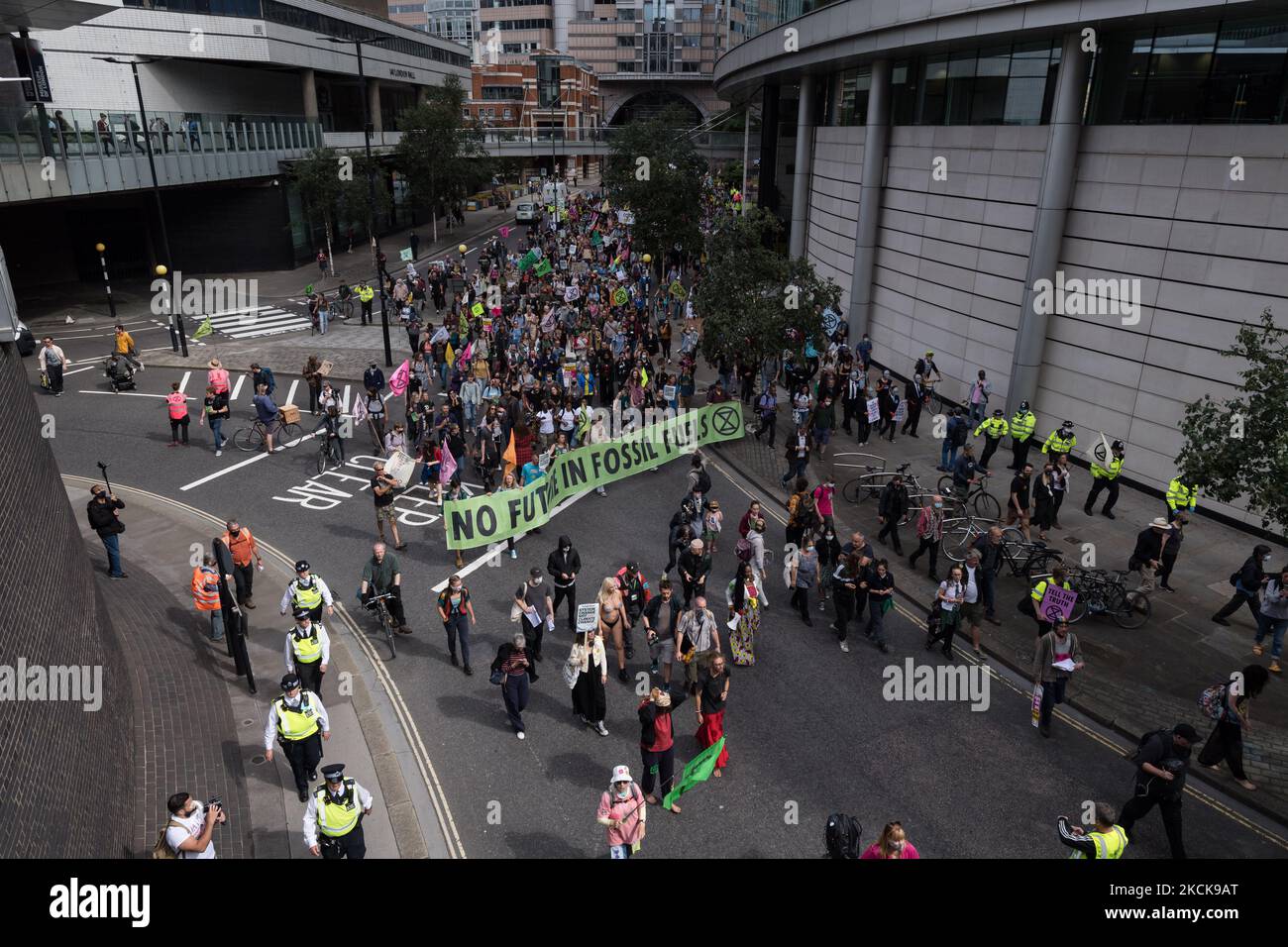LONDON, UNITED KINGDOM - AUGUST 27, 2021: Environmental activists from Extinction Rebellion march through the City of London in a protest against the companies and institutions that are financing, insuring and enabling major fossil fuel projects and extraction of resources in the developing countries of the Global South, demanding change to the colonial system that drives the crises of climate and racism on 27 August 2021 in London, England. Extinction Rebellion activists target the City of London during the two week 'Impossible Rebellion' action to highlight the role of the UK's financial sec Stock Photo