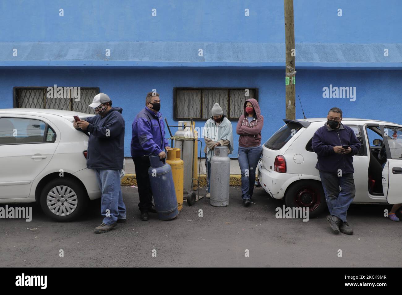 A group of people with gas tanks awaits the start of Gas Bienestar