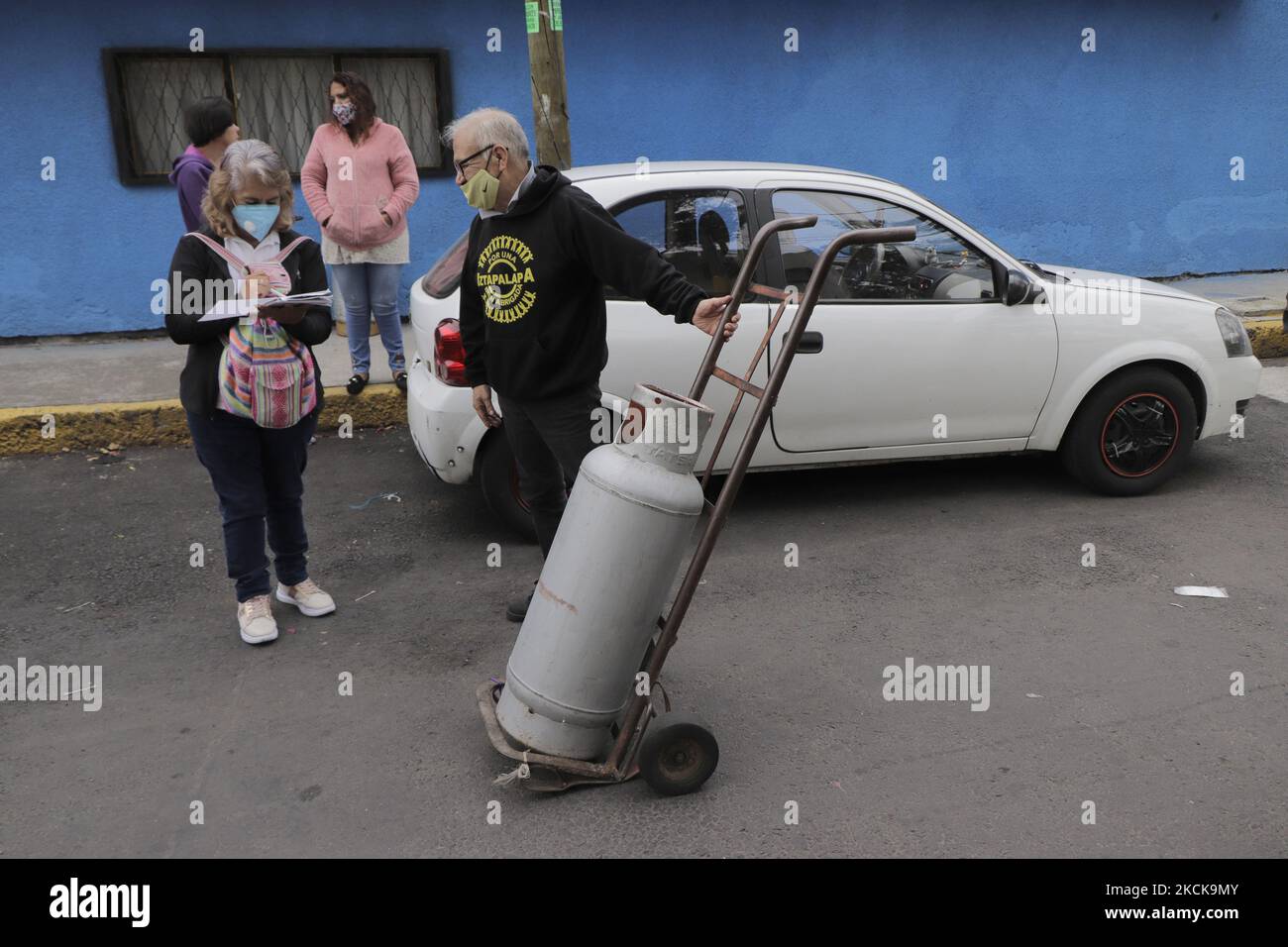 A man carries a gas tank prior to the start of sales of Gas Bienestar