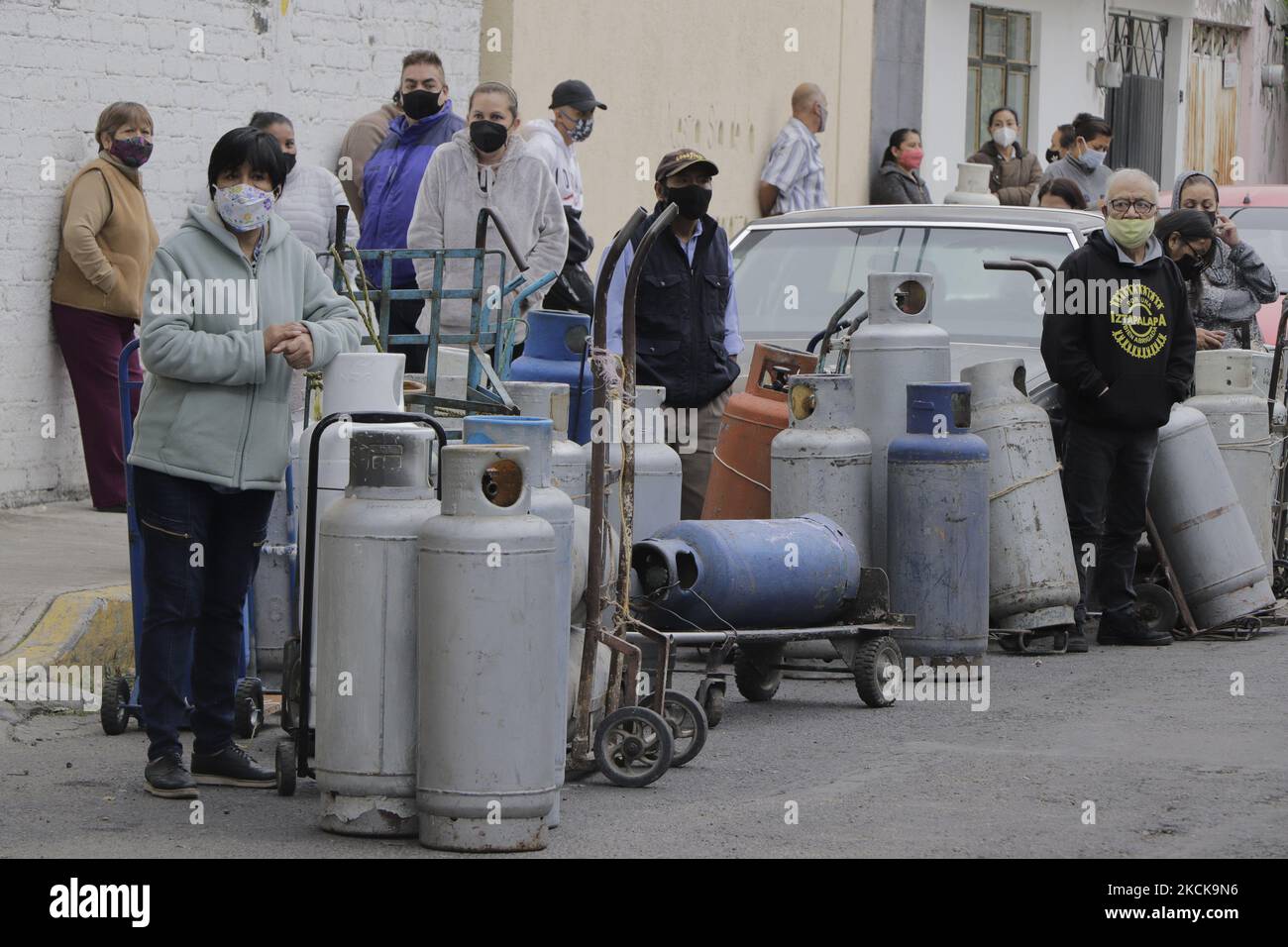 A group of people with gas tanks awaits the start of Gas Bienestar