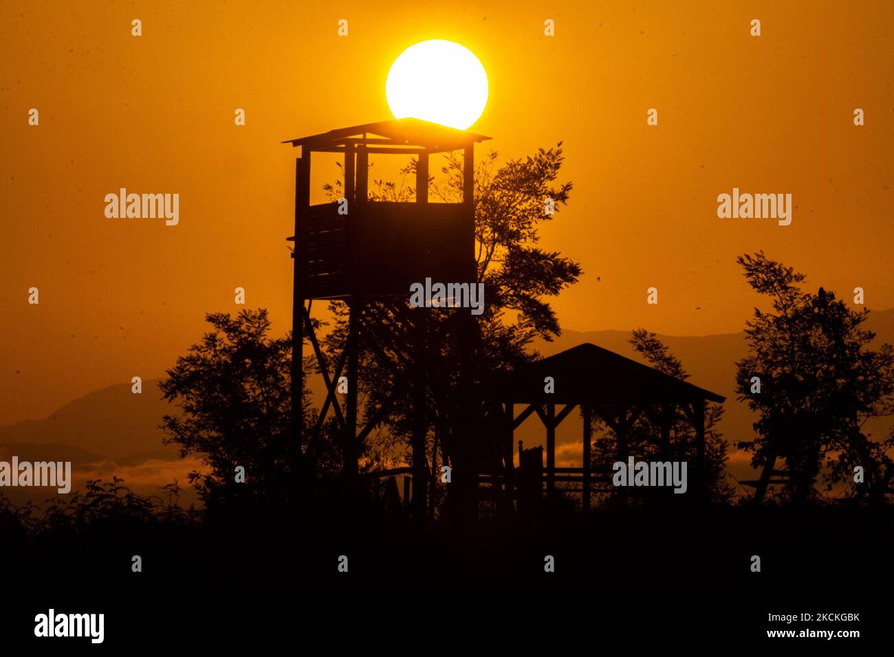 A Watch Tower For Bird Watchers And Visitors Of The Lake With The Sun a-watch-tower-for-bird-watchers-and-visitors-of-the-lake-with-the-sun