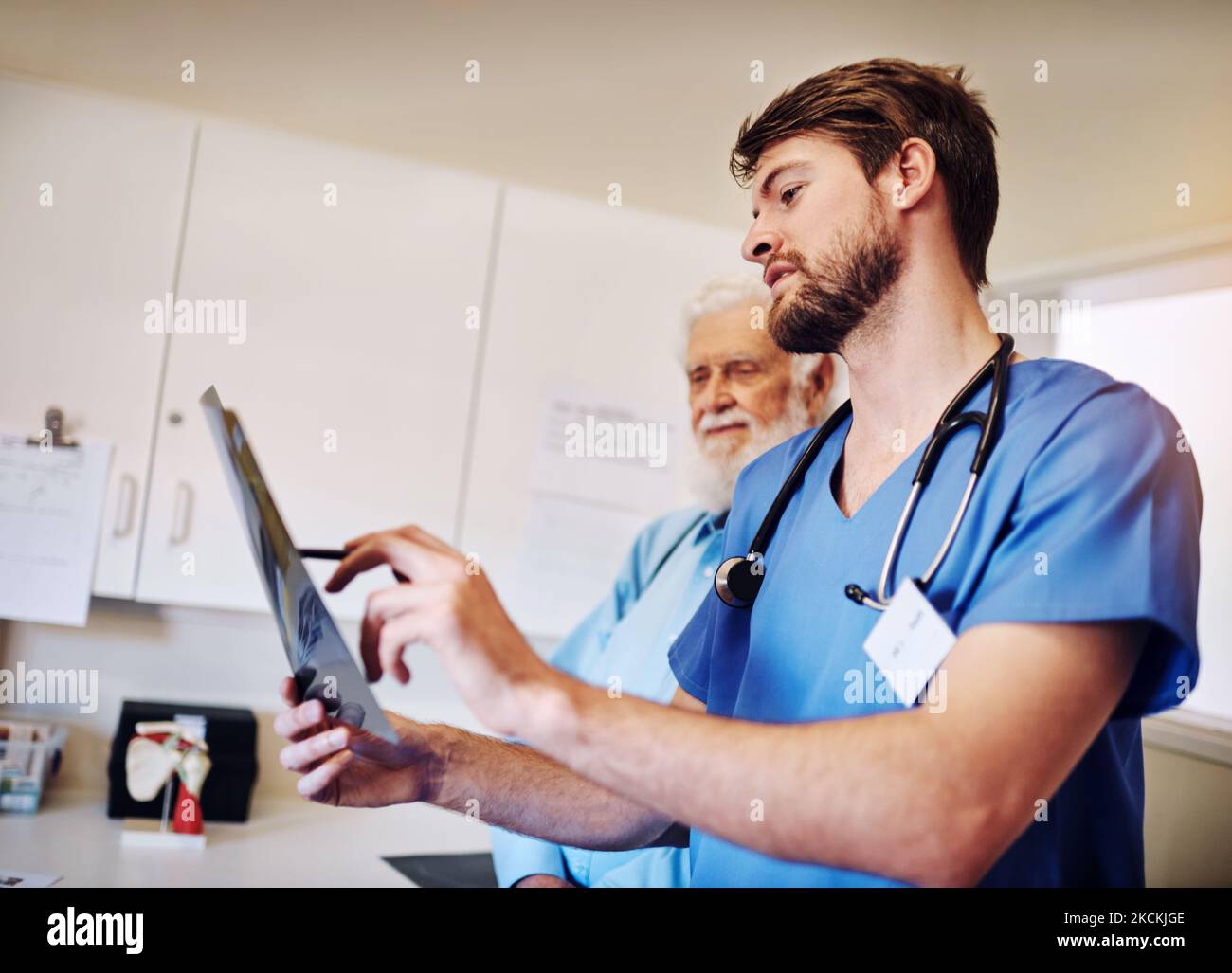 This area needs to be our main focus. a young doctor and his senior patient looking at an x-ray together. Stock Photo