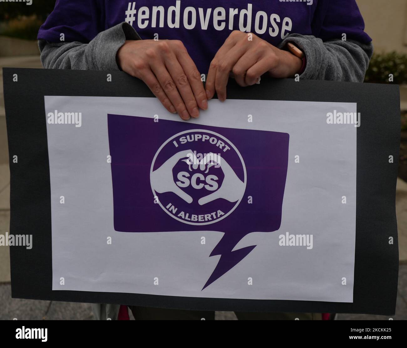 An activist holds a poster that reads 'I support SCS in Alberta' on International Overdose Awareness Day at Capital Plaza outside the Federal Building, overlooking the Alberta legislature, to raise awareness of the number of people dying from overdoses each day. On Tuesday, August 31, 2021, in Edmonton, Alberta, Canada. (Photo by Artur Widak/NurPhoto) Stock Photo
