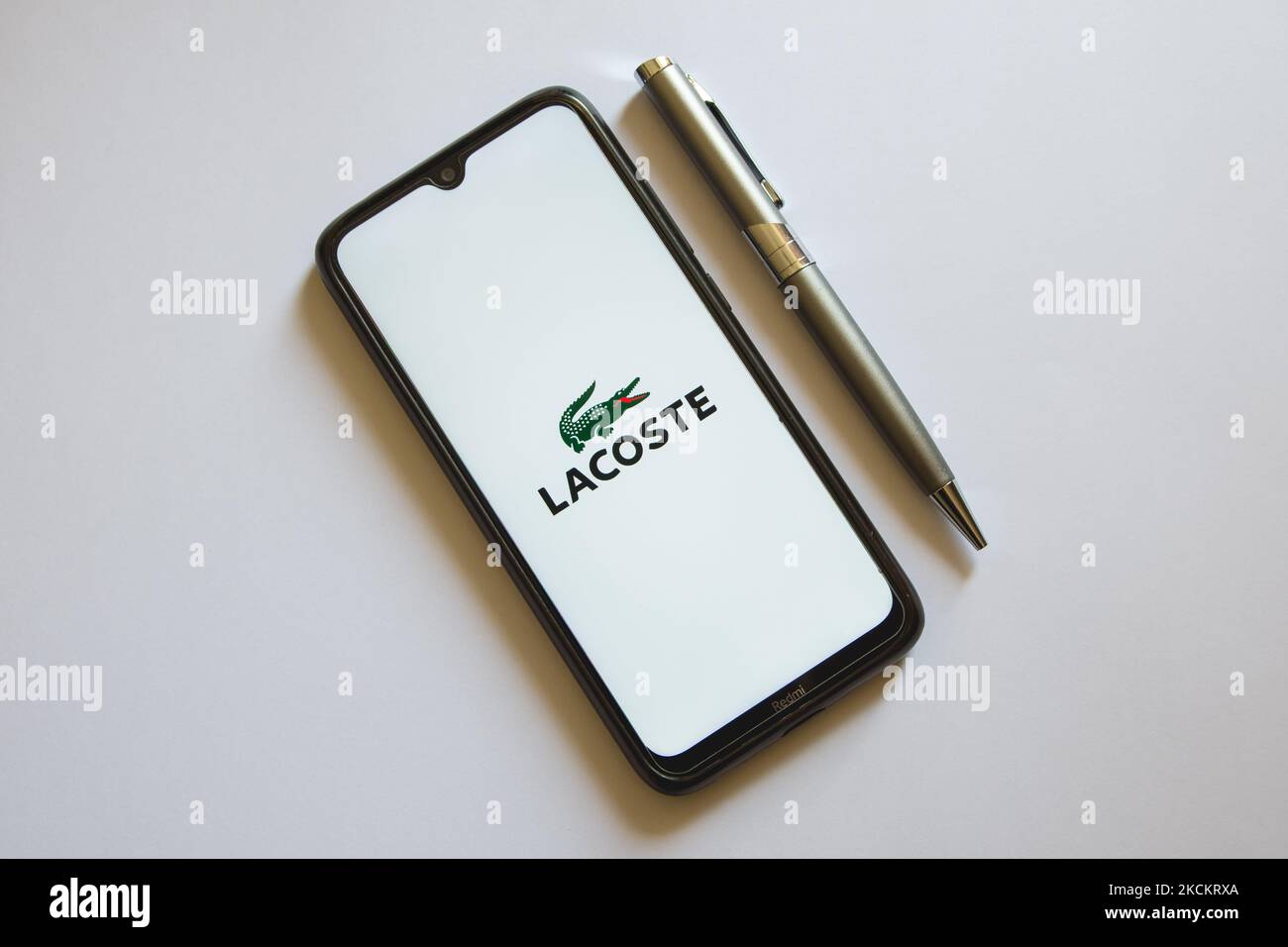In this photo illustration a Lacoste logo is display on a smartphone screen and a pencil in Athens, Greece on September 3, 2021. (Photo by Nikolas Kokovlis/NurPhoto) Stock Photo