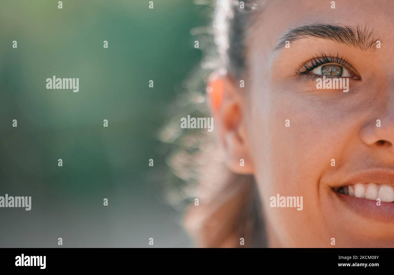Eye, face and smile of woman outdoor for happiness, humanity and kindness while thinking and dreaming about future, goals or vision. Happy young girl Stock Photo